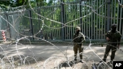 Польские войска охраняют границу с Беларусью за металлическим барьером в Беловежской пуще, 29 мая 2024 года.