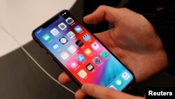 Архивное фото: покупатель тестирует смартфон во время запуска продаж новых iPhone XS и XS Max в магазине-реселлере Apple «re:Store» в Москве, Россия, 28 сентября 2018 года