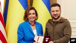 Nan foto sa a ke biwo prezidansyel Ikrenyen an pibliye Dimanch 1 Me Prezidan Ikrenyen an Volodymyr Zelenskyy (a dwat) remet Lod Prenses Olga a bay Lide La Chanm de Reprezantan Etazini an, Nancy Pelosi nan vil Kyev. 