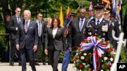 Prezidan Joe Biden, Vis Prezidan Kamala Harris ak Sekrete Defans Lloyd Austin depoze yon jeb fle devan Tonbo Solda Enkoni a nan simitye nasyonal Arlington nan, pou Memorial Day (Jou du Souvni), Lendi 30 Me, 2022. 