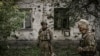 FILE - Ukrainian servicemen stand in the city of Lysytsansk at the eastern Ukrainian region of Donbas on May 30, 2022,