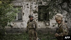 FILE - Ukrainian servicemen stand in the city of Lysytsansk at the eastern Ukrainian region of Donbas on May 30, 2022,