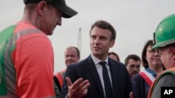 Prezidan Franse a ak kandida a la prezidans santris pou re-eleksyon Emmanuel Macron pale ak travaye pandan lap vizite yon teren konstriksyon nan Denain, rejyon no La Frans, Lendi 11 Avril 2022.