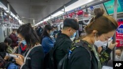 Commuters wearing face masks ride a subway train in Beijing, April 12, 2022. The U.S. has ordered all nonemergency consular staff to leave Shanghai, which is under a tight lockdown to contain a COVID-19 surge.