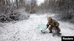 Военнослужащий 80-й отдельной десантно-штурмовой бригады ВСУ отключает терминал Starlink на время празднования православного Рождества в прифронтовом районе на востоке Украины. 6 января 2023 года.