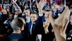 Prezidan Franse a Emmanuel Macron yon kandida santris bay patizan li yo lanmen nan moman li rive nan yon miting politik nan vil Paris, Samdi 2 Avril 2022. 