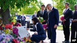 File - New York Gov. Kathy Hochul looks at a memorial at the scene of a shooting at a supermarket in Buffalo, N.Y., Tuesday, May 17, 2022. in response to gun violence, Hochul signed 10 gun control bills into law on Monday.