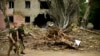 FILE - Ukrainian servicemen walk past a building heavily damaged in a Russian bombing in Bakhmut, eastern Ukraine, eastern Ukraine, May 28, 2022. 