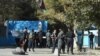 Policemen stand guard at an entrance gate of the Kabul University in Kabul on November 2, 2020. 