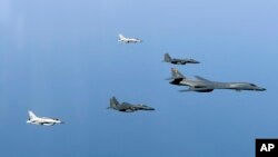 In this photo provided by South Korean Defense Ministry, a U.S. Air Force B-1B bomber, right, and South Korean fighter jets conduct a joint training exercises over the Korean Peninsula Wednesday, March 22, 2017. North Korea's latest missile launch ended in failure on Wednesday as the United States sent a supersonic bomber streaking over ally South Korea in a show of force against the North, officials said. (South Korean Defense Ministry via AP)