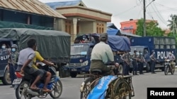 A man wearing a protective face mask rides a bicycle amid the outbreak of the coronavirus disease (COVID-19), in Sittwe, Rakhine State, Myanmar August 27, 2020. REUTERS/Stringer NO RESALES NO ARCHIVES