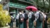 Students wait outside a school entrance in Sittwe, capital of western Rakhine State on June 1, 2021. - Schools in Myanmar opened on June 1 for the first time since the military seized power, but teachers and students are set to defy the junta's calls for 