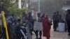 Buddhist monks walk expecting alms as group of policemen(AP Photo/Gemunu Amarasinghe)