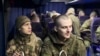 This grab taken from a handout footage released by the Russian Defence Ministry on January 3, 2024 shows Russian prisoners of war (POWs) inside a bus at the Russian-Ukrainian state border in the Belgorod region following a swap.