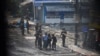 Army officers detain a man during a protest against the military coup in Yangon, Myanmar, March 2, 2021. Picture taken from behind a window. REUTERS/Stringer