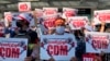 Anti-coup protesters hold posters with "CDM," initials that stand for Civil Disobedience Movement, as they gather outside the Hledan Centre in Yangon, Myanmar, Sunday, Feb. 14, 2021. Daily mass street demonstrations in Myanmar are on their second week, with neither protesters nor