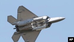 F-22 в полёте с раскрытым отсеком для вооружения. Такие самолёты были применены ВВС США для уничтожения китайского аэростата-шпиона и неопознанного объекта над Аляской. Архивное фото