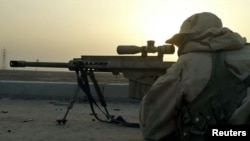 A sniper of the U.S. Marine Expeditionary Unit (MEU)takes aim in theport city of Umm-Qasr in southern Iraq on March 23, 2003 as his unitmet with pockets of resistance from the Republican Guard in aresidential area beside the port. Iraqi troops and paramil