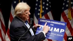 Campaign 2016 Trump: Republican presidential candidate Donald Trump holds up a "Christian Conservatives for Trump" sign at a rally, Wednesday, Sept. 28, 2016, in Council Bluffs, Iowa.