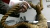 FILE - A museum worker shows a noose on display in a Iraqi museum in Baghdad, December 30, 2008.