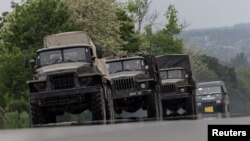 Military vehicles are see moving along a road, amid Russia's invasion of Ukraine, in the Donetsk region