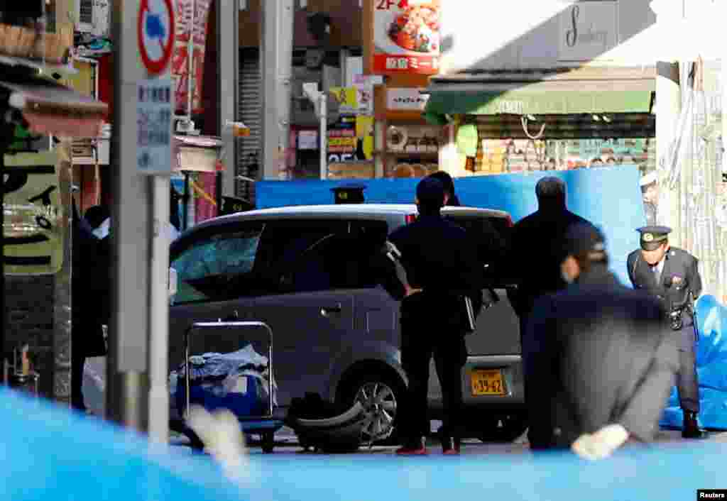 Policemen stand next to a car which plowed into pedestrians on New Year's day in Tokyo, Japan, Jan. 1, 2019.