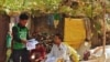 r Amin (wearing white), a Rohingya community leader, collects details from a fellow community member 