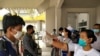 Migrant workers from Myanmar get their temperatures taken by healthcare workers at the Myawaddy border office after passing through border gate at Myawaddy, Myanmar, after leaving Thailand due to the coronavirus disease (COVID-19) outbreak, March 24, 2020