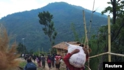 People displaced by fighting in north-western Myanmar between junta forces and anti-junta fighters walk in Chin State, Myanmar, May 31, 2021. Picture taken May 31, 2021. REUTERS/Stringer