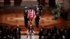 Members of the clergy and a military honor guard carrying the flag-draped casket depart at the conclusion of the state funeral for former President George H.W. Bush in the Washington National Cathedral in Washington, Dec. 5, 2018. 