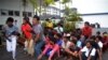 Illegal immigrants from Myanmar and Bangladesh arrive at the Langkawi police station's multi purpose hall in Langkawi, Malaysia on Monday, May 11, 2015. Hundreds of migrants abandoned at sea by smugglers in Southeast Asia have reached land and relative sa