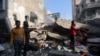 Palestinians inspect a house destroyed in an Israeli strike, in Khan Younis