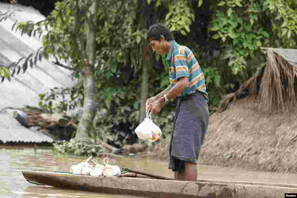 A man holds food collected from local donors at a village in Kawlin township, Sagaing division