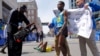 Winner of the men's division Lelisa Desisa Benti of Ethiopia (R) is wrapped in a towel as third place finisher compatriot Gebregziabher "Gebre" Gebremariam (C) lays on the ground during the 117th Boston Marathon in Boston, Massachusetts April 15, 2013. RE