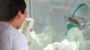 A medical officer (R) takes a swab sample from a man to be tested for the COVID-19 coronavirus at a quarantine centre in Yangon on May 16, 2020. (Photo by Ye Aung THU / AFP)