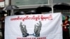 Journalists hold a banner as they protest against a law