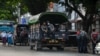 Police prepare to search for protesters, who were taking part in a demonstration against the military coup, in downtown Yangon on May 6, 2021. (Photo by STR / AFP)