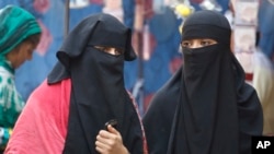 FILE - Indian Muslim women talk while walking through a market in Ahmadabad, India, Dec. 29, 2017. 