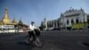 A man wearing a face mask rides a bike on an empty road, 