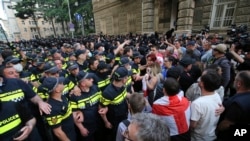 Полиция оттесняет демонстрантов во время акции протеста оппозиции против законопроекта об «иностранных агентах» у здания парламента в Тбилиси, Грузия, 1 мая 2024 года